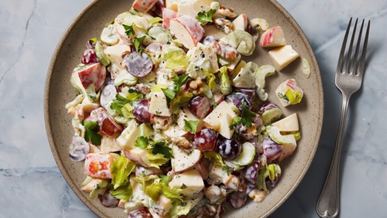Classic Waldorf salad with crisp apples, grapes, walnuts, and celery in creamy dressing.