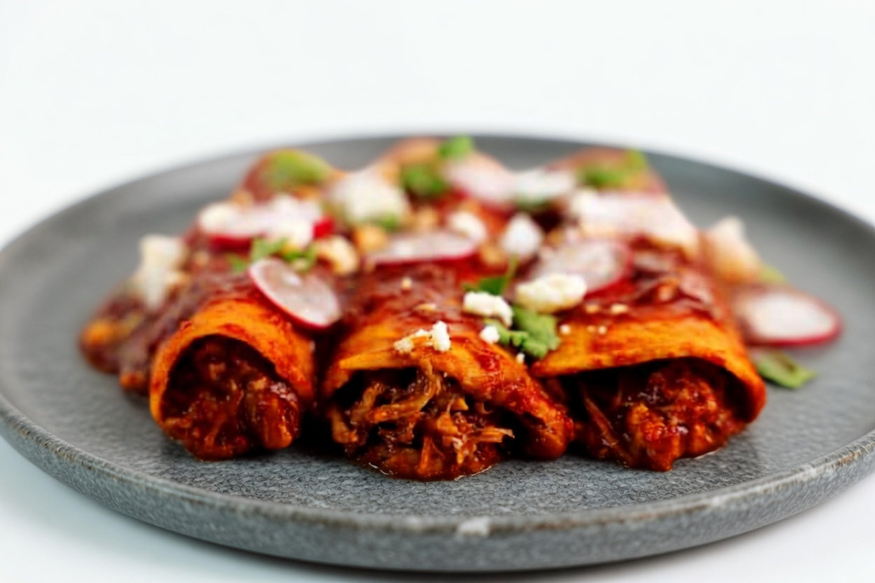 Shredded beef enchiladas smothered in red sauce with melted cheese, radish and sour cream